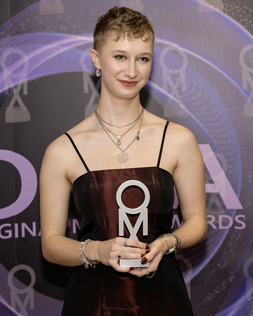 photograph of Zara (stage name Chasing Leaves), on the red carpet with her Original Music Awards winners trophy.