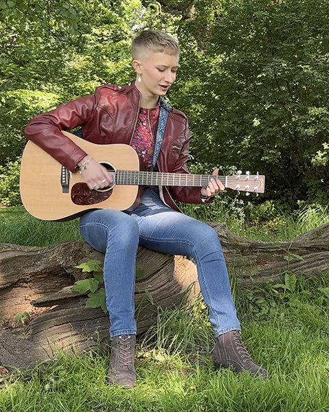 Zara's song being played unplugged in a woodland scene